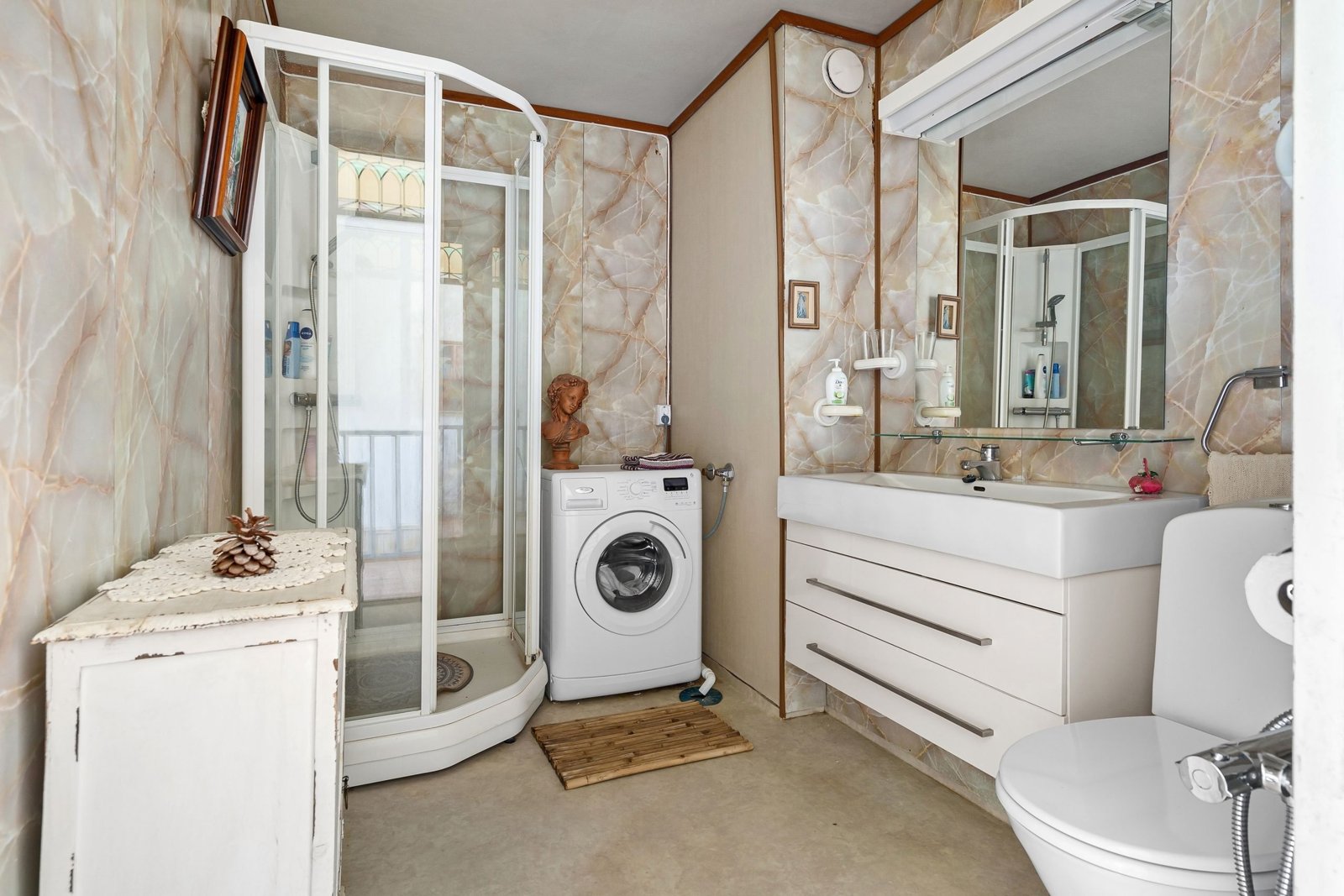 Salle de bain compacte de 3 m² avec douche à l'italienne, meuble vasque suspendu et rangements muraux.